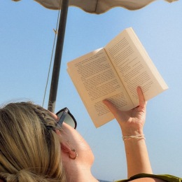 a woman laying down and reading a book