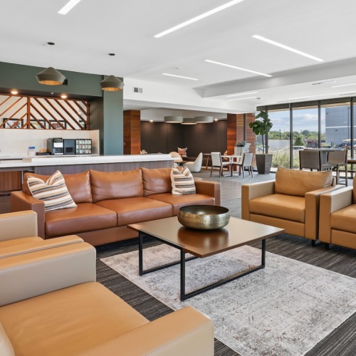 a clubroom with a couch, tables and chairs
